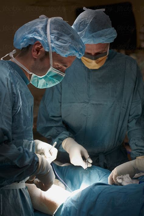 Close Up Of Two Surgeons At Work In The Operating Room By Stocksy