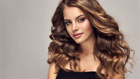 Woman with beauty long brown hair , posing at studio. Images hairstyles Gray background Face Glance Beautiful ...