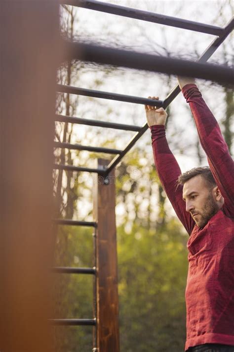 Man Doing Pull Ups While Working Out In Street Workout Park Stock Photo