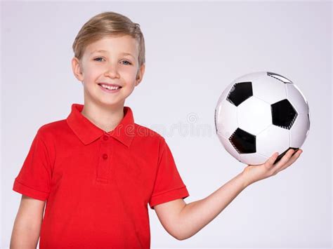 Photo Of A Smiling Child In Sportswear Holding Soccer Ball On A Palm