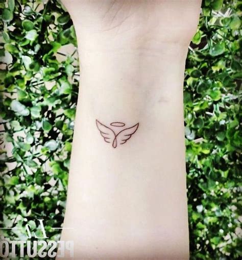 Small Angel Wings Tattoo Wrist Tattoo Green Bushes In The Background