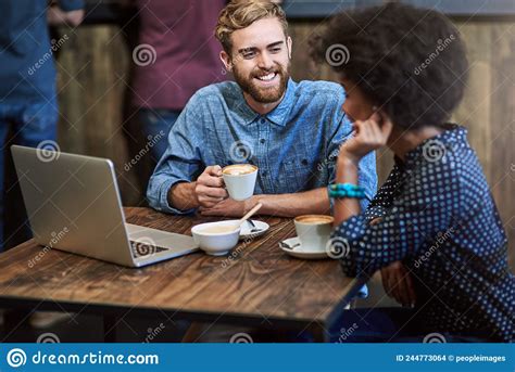 Catching Up Over Coffee Shot Of Two People Sitting In A Cafe Drinking