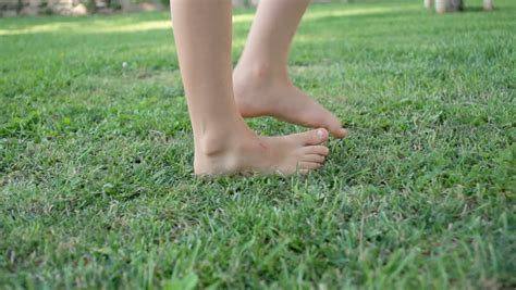 Slow Motion Shot Of A Childs Bare Feet Walking Over Green Grass Stock