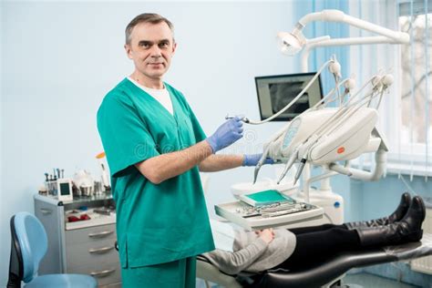 Portrait Of Senior Male Dentist With Dental Instruments In The Dental