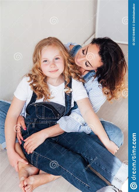 Mom Brunette And Daughter Blonde In Jeans Sit On The Floor Stock Image Image Of Daughter