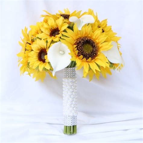 A Bridal Bouquet With Sunflowers And Calla Lilies On A White Background