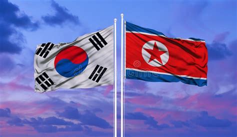 South And North Korea Flags Against Blue Sky Background Stock
