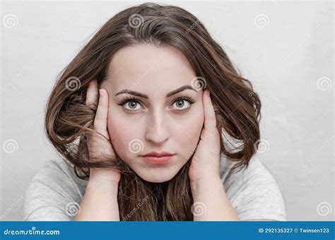Woman Calmly Looks Into Camera Holding Long Hair Near Face With Hands Bright Makeup Stock