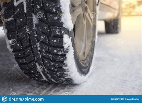 Winter Studded Tires On Snowy Road Wheels Of The Car Standing On