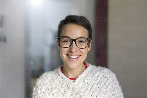 Portrait Of A Smiling Young Woman With Short Hair Wearing Glasses