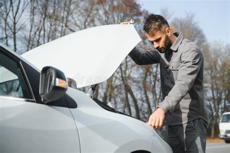 Young Upset Casual Man Trying To Fix His Broken Car Outdoors Man