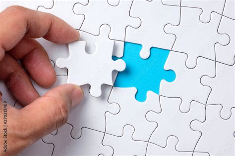 Hand Placing The Last Jigsaw Puzzle Piece Or Holding Missing Jigsaw