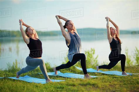 Group Of Active Young People Doing Yoga Outdoors Stock Photo Dissolve
