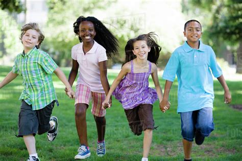 Happy Children Holding Hands And Running In Park Stock Photo Dissolve