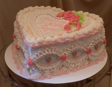 heart shaped sour cream white cake covered in cherry flavored butter cream embellished with fon