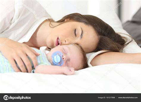 Tired Mother Sleeping With Her Baby Stock Photo By ©antonioguillemf