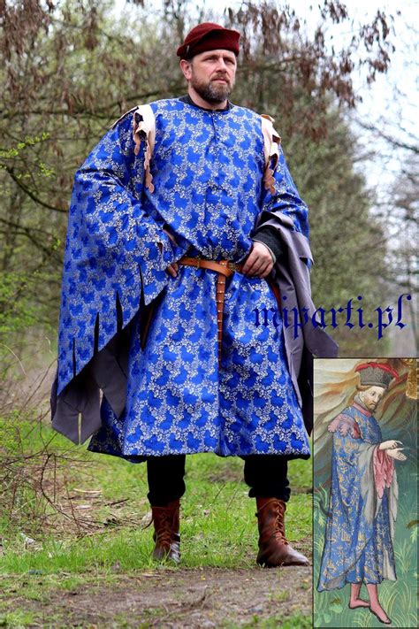 A Man Dressed In Medieval Clothing Standing Next To A Tree With An