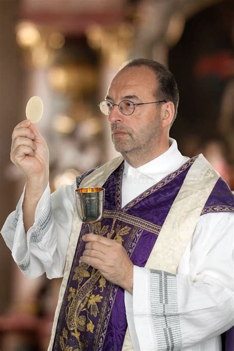 Sacerdote Católico Durante La Comunión En La Adoración Imagen De