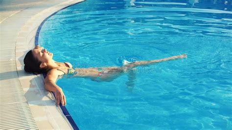 junge brunettefrau im bikini und in der sonnenbrille geht in swimmingpool und schwimmen am