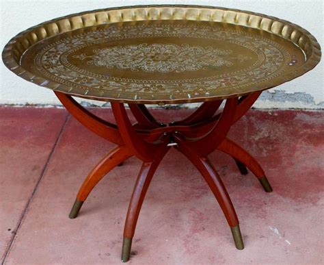 The legs are fancily turned with a carved all over design and shell inserts. Mid Century Oval Brass Tray Coffee Table Moroccan at 1stdibs