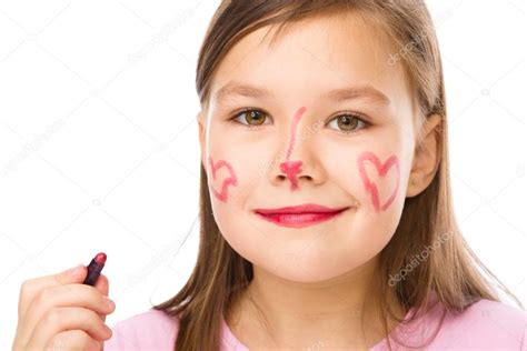 Little Girl Is Applying Lipstick On Her Cheek — Stock Photo © Kobyakov