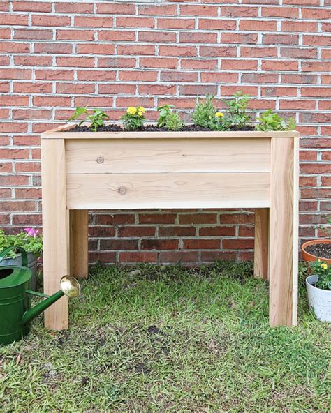 Once all four legs are in place, flip your garden onto its legs and we are ready to add the landscaping fabric. How to Build a Raised Garden Bed with Legs - Angela Marie Made