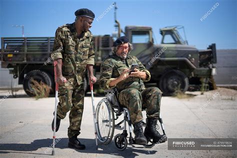 Injured Army Soldier Holding Crutches While Standing With Disabled