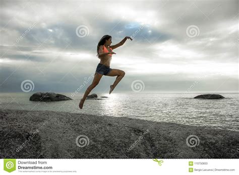 Woman Jumping On A Rock At Sunset On Bakovern Beach Cape Town Stock Image Image Of Cloudy