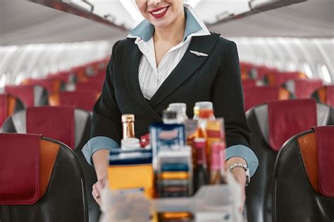 hôtesse de l air transportant un chariot de nourriture dans la cabine passagers d un avion à