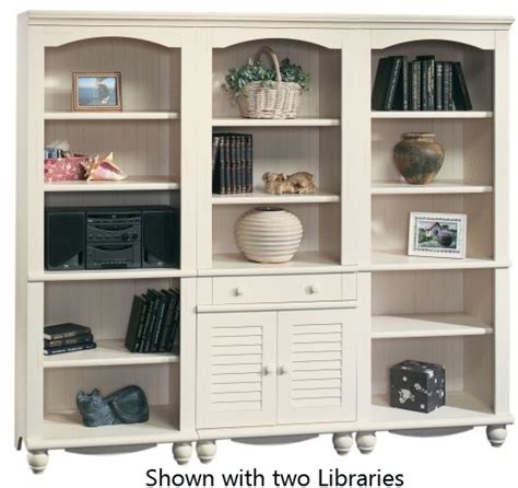 A White Bookcase Filled With Lots Of Books Next To A Vase And Other Items