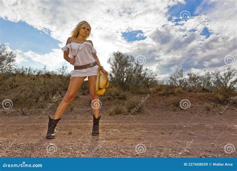A Lovely Blonde Model Poses Outdoors Wearing Lingerie In The Desert