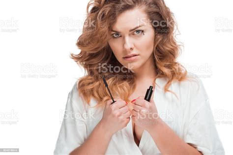 Portrait Of Serious Woman Looking At Camera With Mascara In Hands