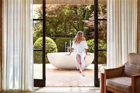 Woman Sitting On Edge Of Outdoor Bathtub At Luxury Resort By Stocksy