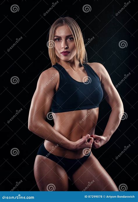 Fille Sportive Avec De Grands Muscles Dans Les Vêtements De Sport Noirs