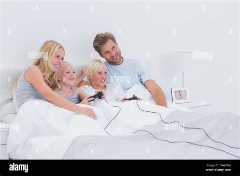 Siblings Playing Video Games With Parents Watching Stock Photo Alamy