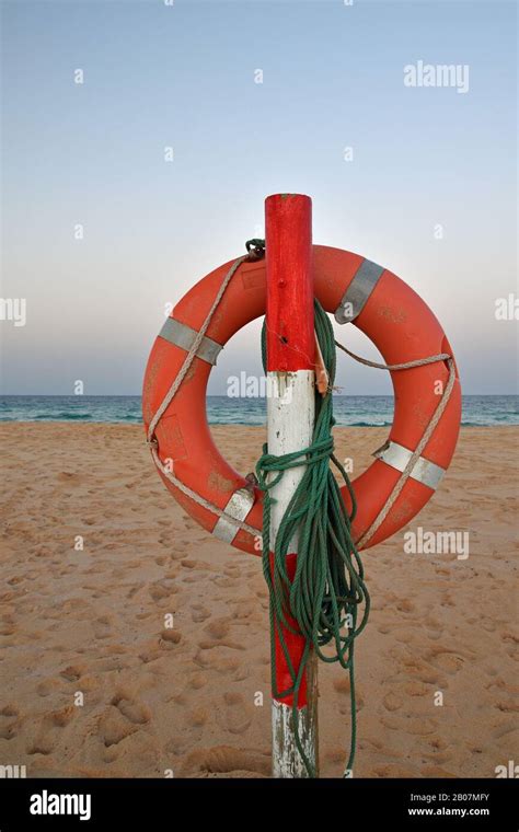 Orange Life Saver Ring On Wooden Post With Green Rope On Corralejo
