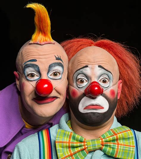 Two Clowns With Their Faces Painted To Look Like They Are Hugging Each Other S Head