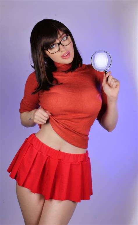 A Woman With Glasses Holding A Magnifying Glass In One Hand And Wearing A Red Skirt On The Other