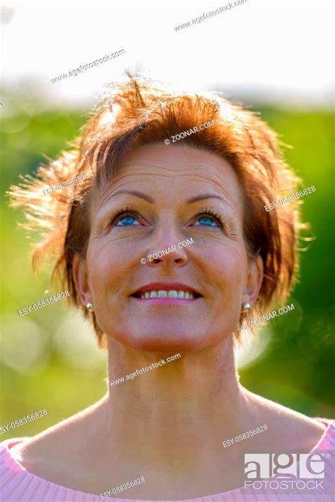 portrait of mature beautiful scandinavian woman with short hair relaxing in nature outdoors