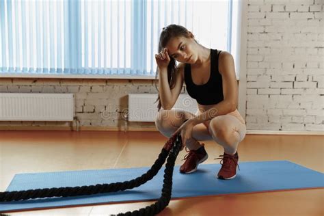 Woman With Battle Ropes Exercise In The Fitness Gym Stock Photo