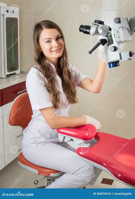 Attractive Female Doctor With Microscope In The Modern Dentist Office Stock Photo Image Of