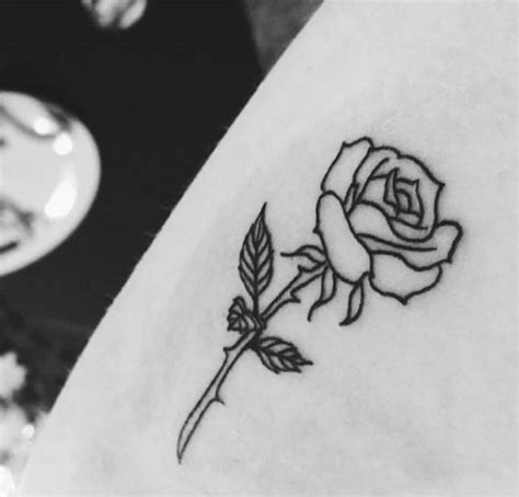 A Small Rose Tattoo On The Side Of A Woman S Right Arm And Shoulder