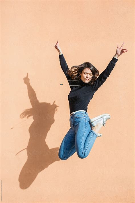 Brunette Girl Jumping In Front Of A Wall By Stocksy Contributor