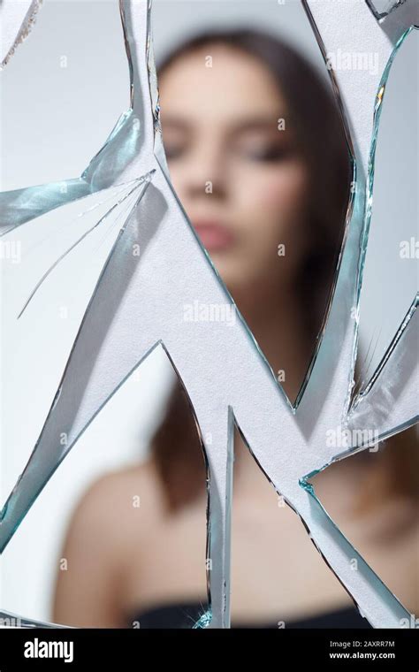 Young Woman Looks In A Broken Mirror Out Of Focus Blurred Portrait Of