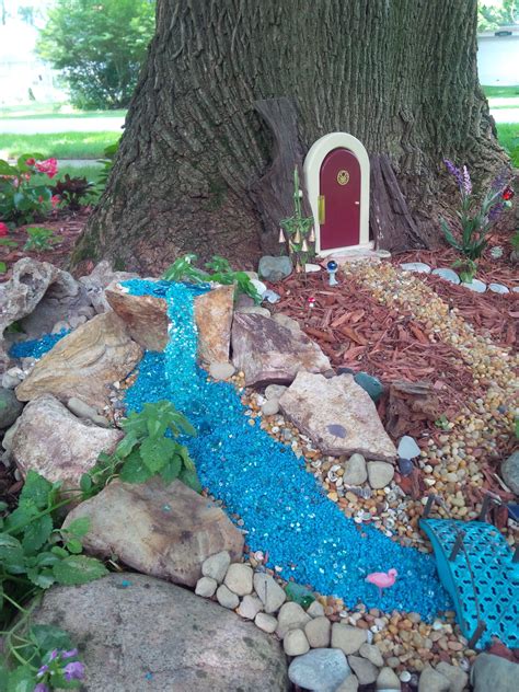 A Fairy Garden In The Shape Of A Tree With Rocks Gravel And A Door