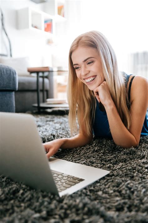 Happy woman using laptop computer on carpet at the floor | Free Photo