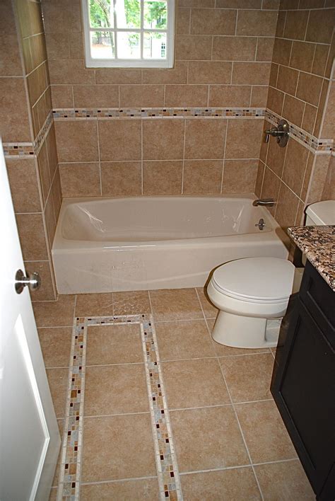 Go for mosaic glass tiles in a recurring border, or use a border of black tiles to divide a white and brown mosaic tile creation, breaking up the wall space. Bathroom Floor Tile Home Depot | Bathroom tile designs ...