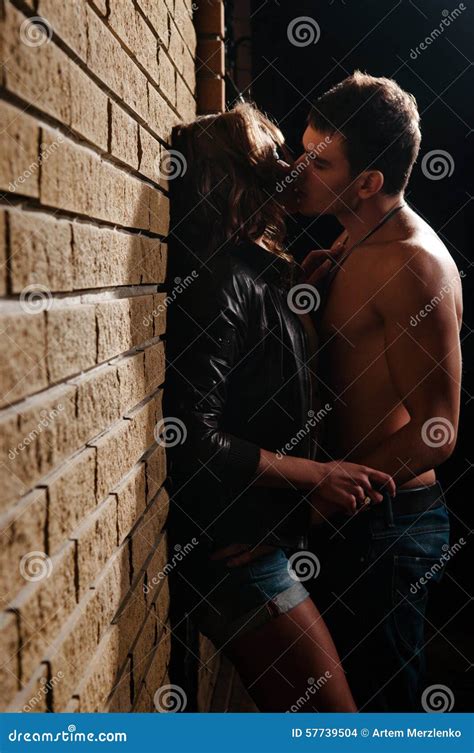 Beautiful Young Couple Kissing At Evening Near Brick Wall Royalty Free Stock Image