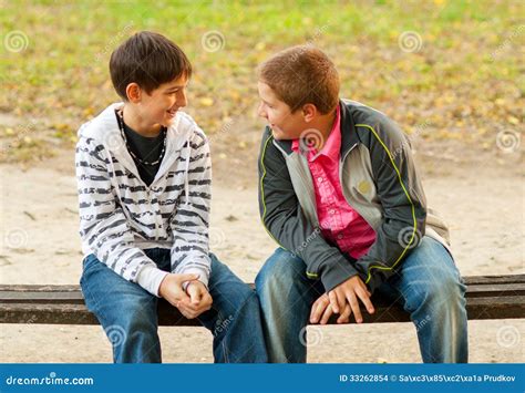 Two Teenage Friends Talking In The Park Stock Photo Image Of Bench