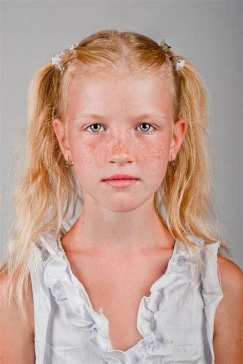 Portrait Of Blonde Girl With A Freckled Face And Two Tails Stock Photo